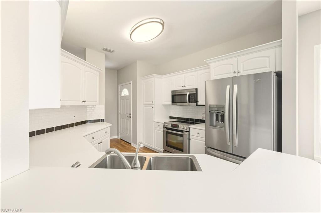 7005 Pinnacle Lane, Unit 1501 Naples, FL 34110 - Photo 16 of 46 a kitchen with stainless steel appliances a refrigerator sink and stove