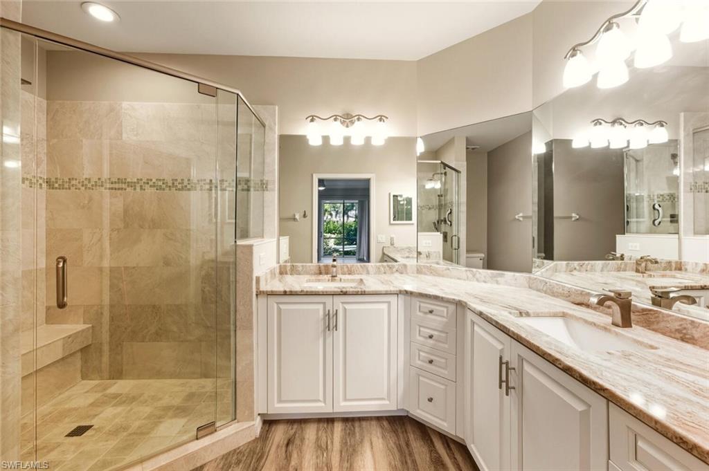 7005 Pinnacle Lane, Unit 1501 Naples, FL 34110 - Photo 20 of 46 a bathroom with a granite countertop sink a mirror and a shower