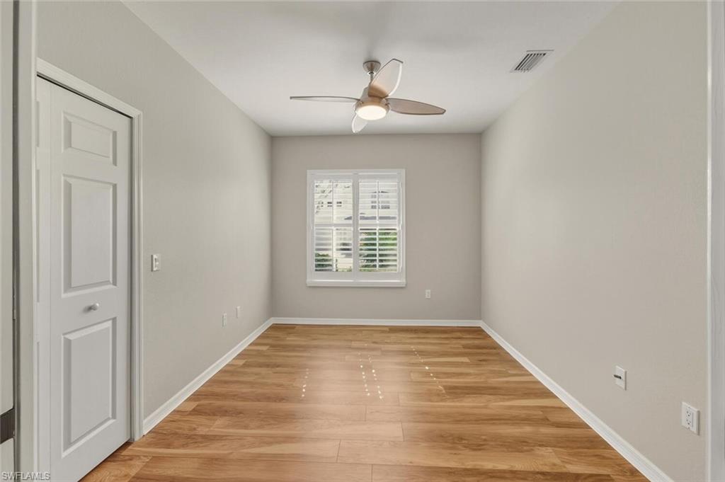7005 Pinnacle Lane, Unit 1501 Naples, FL 34110 - Photo 22 of 46 a view of an empty room with wooden floor and a window
