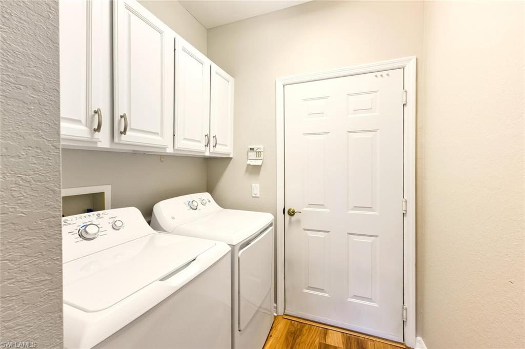 7005 Pinnacle Lane, Unit 1501 Naples, FL 34110 - Photo 25 of 46 a view of washer and dryer with kitchen in the background