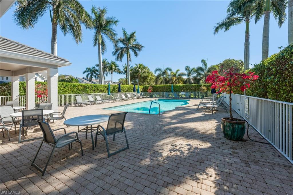 7005 Pinnacle Lane, Unit 1501 Naples, FL 34110 - Photo 29 of 46 a view of a backyard with a patio table and chairs