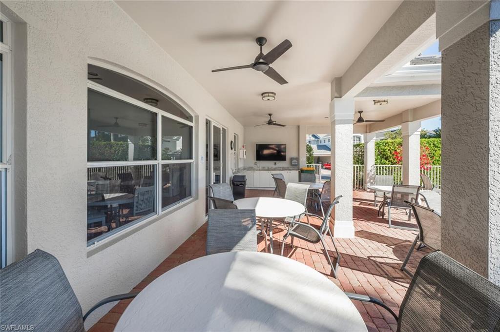 7005 Pinnacle Lane, Unit 1501 Naples, FL 34110 - Photo 30 of 46 a living room with furniture a fireplace and a large window