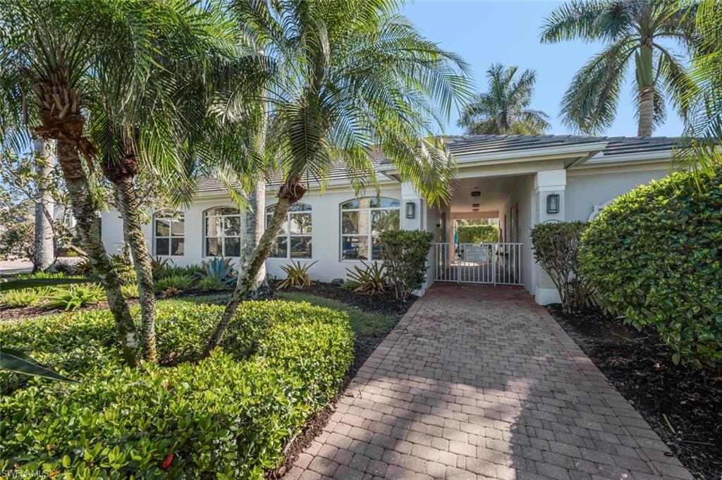 7005 Pinnacle Lane, Unit 1501 Naples, FL 34110 - Photo 35 of 46 a front view of a house with a garden