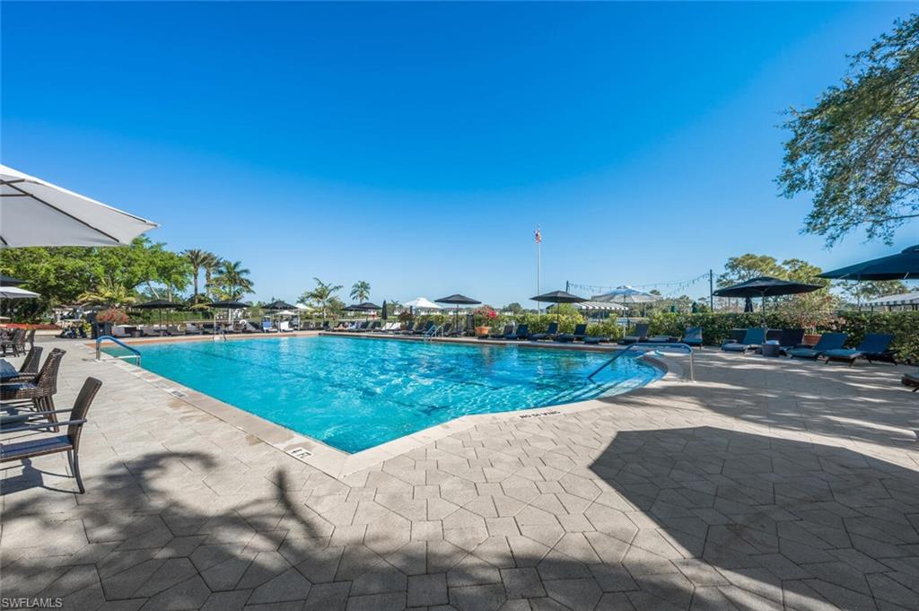 7005 Pinnacle Lane, Unit 1501 Naples, FL 34110 - Photo 41 of 46 a view of a lake with a yard and a large tree