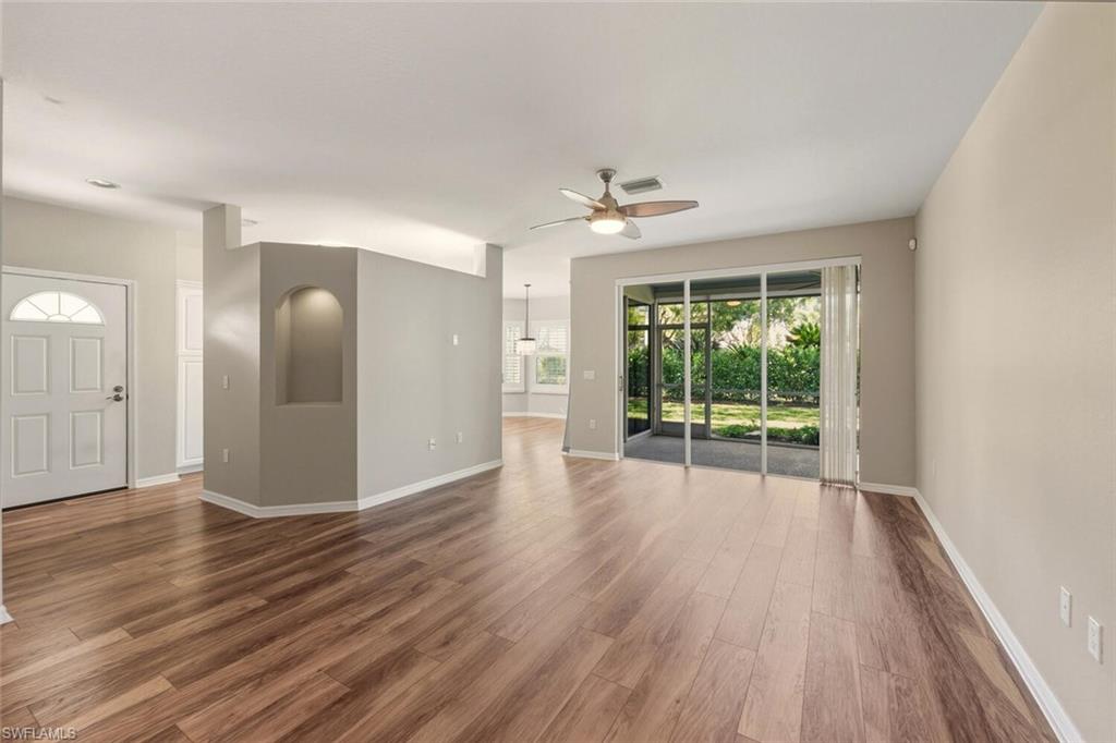 7005 Pinnacle Lane, Unit 1501 Naples, FL 34110 - Photo 5 of 46 a view of an empty room with wooden floor and a window