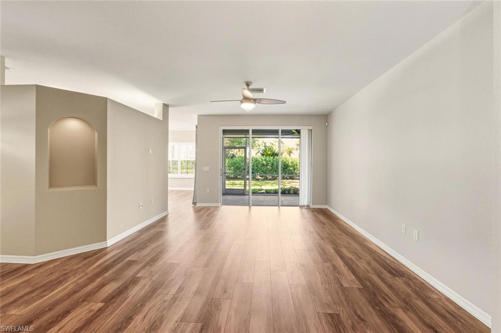 7005 Pinnacle Lane, Unit 1501 Naples, FL 34110 - Photo 6 of 46 a view of an empty room with wooden floor and a window