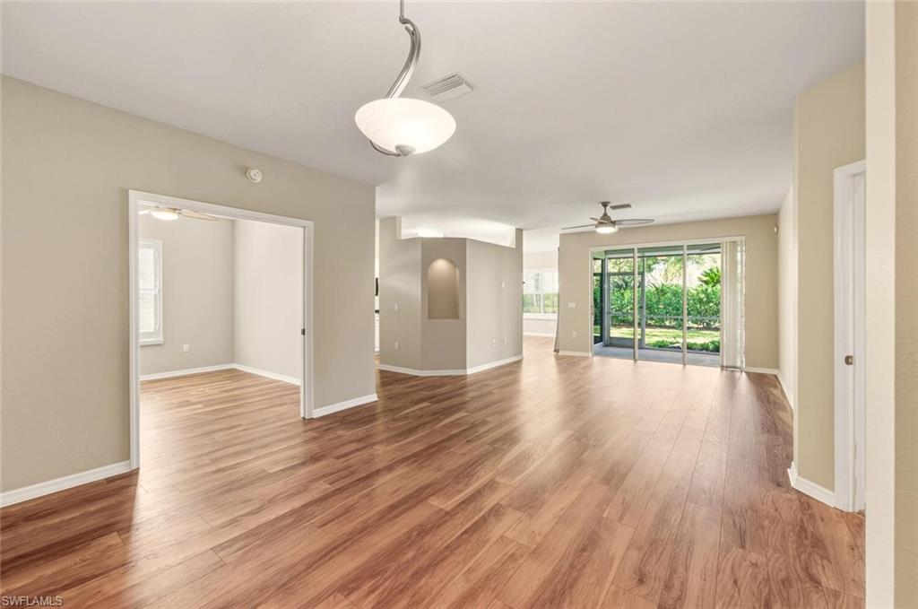 7005 Pinnacle Lane, Unit 1501 Naples, FL 34110 - Photo 8 of 46 a view of an empty room with wooden floor and a window