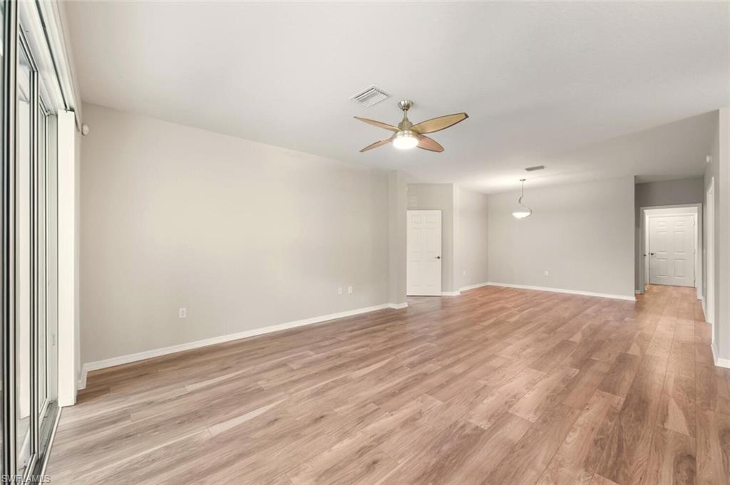 7005 Pinnacle Lane, Unit 1501 Naples, FL 34110 - Photo 9 of 46 a view of empty room with wooden floor and ceiling fan