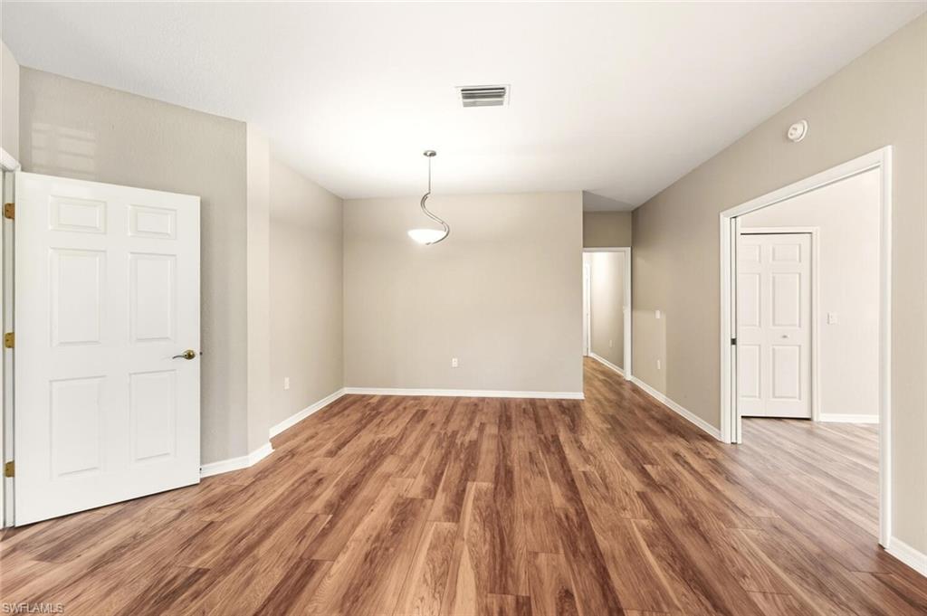 7005 Pinnacle Lane, Unit 1501 Naples, FL 34110 - Photo 10 of 46 wooden floor in an empty room with a window