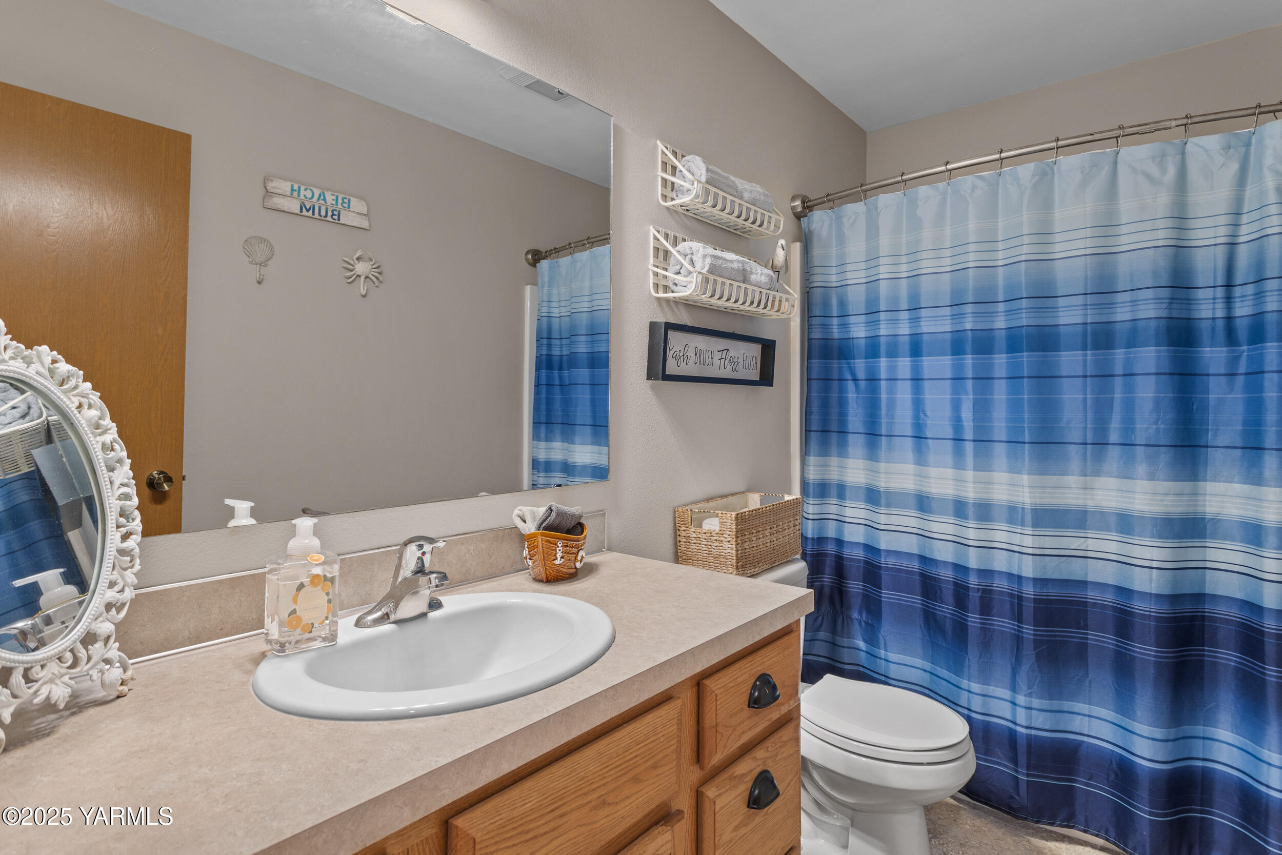 150 Solar Lane Yakima, WA 98901 - Photo 15 of 27 a bathroom with a sink a toilet a mirror and shower curtain