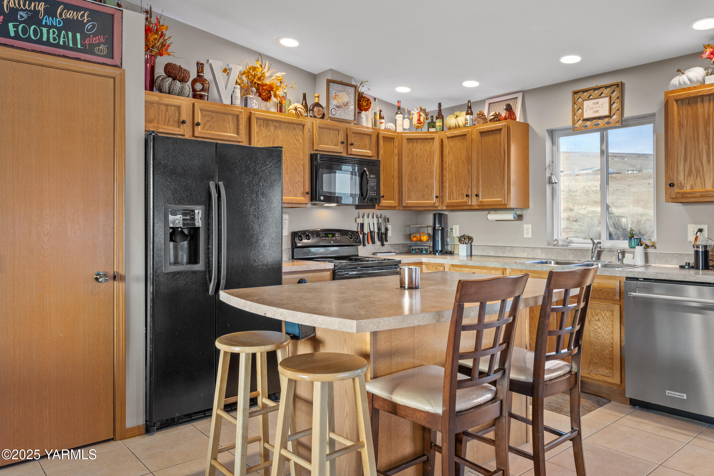 150 Solar Lane Yakima, WA 98901 - Photo 3 of 27 a kitchen with stainless steel appliances granite countertop a stove a refrigerator a sink a dining table and chairs with wooden floor