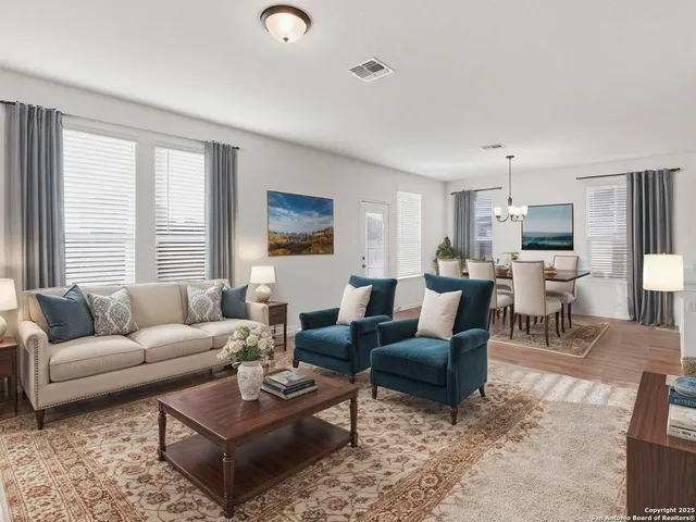 a living room with furniture wooden floor and a large window