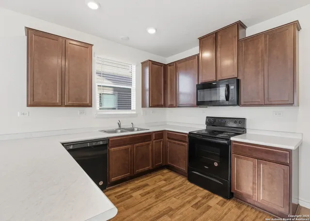 a kitchen with stainless steel appliances granite countertop a sink stove and cabinets