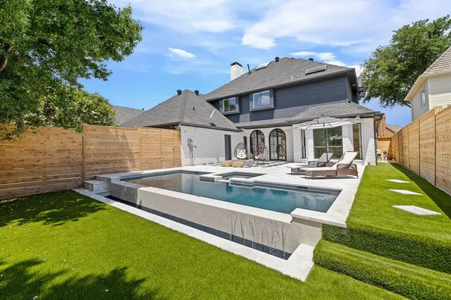 a view of a house with swimming pool and a yard