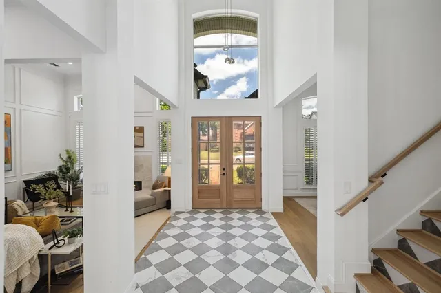 a view of a hallway to a livingroom with furniture and windows