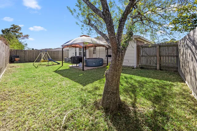 a view of backyard with a barn and a large tree