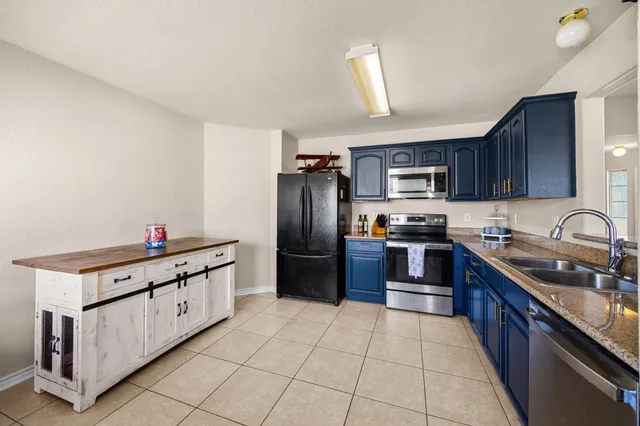 a kitchen with stainless steel appliances granite countertop a refrigerator sink and cabinets