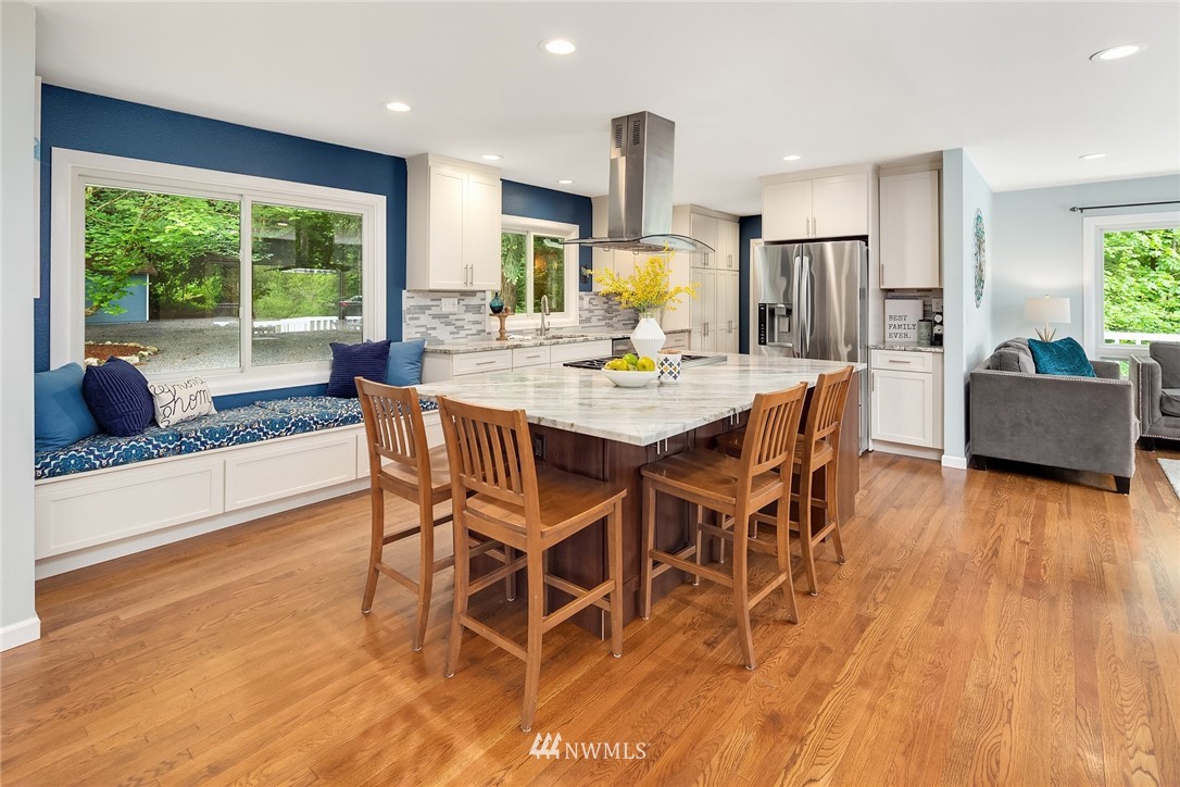 27819 Southeast Issaquah-Fall City Road Fall City, WA 98024 - Photo 12 of 39 a dining room with furniture wooden floor a potted plant and a kitchen view