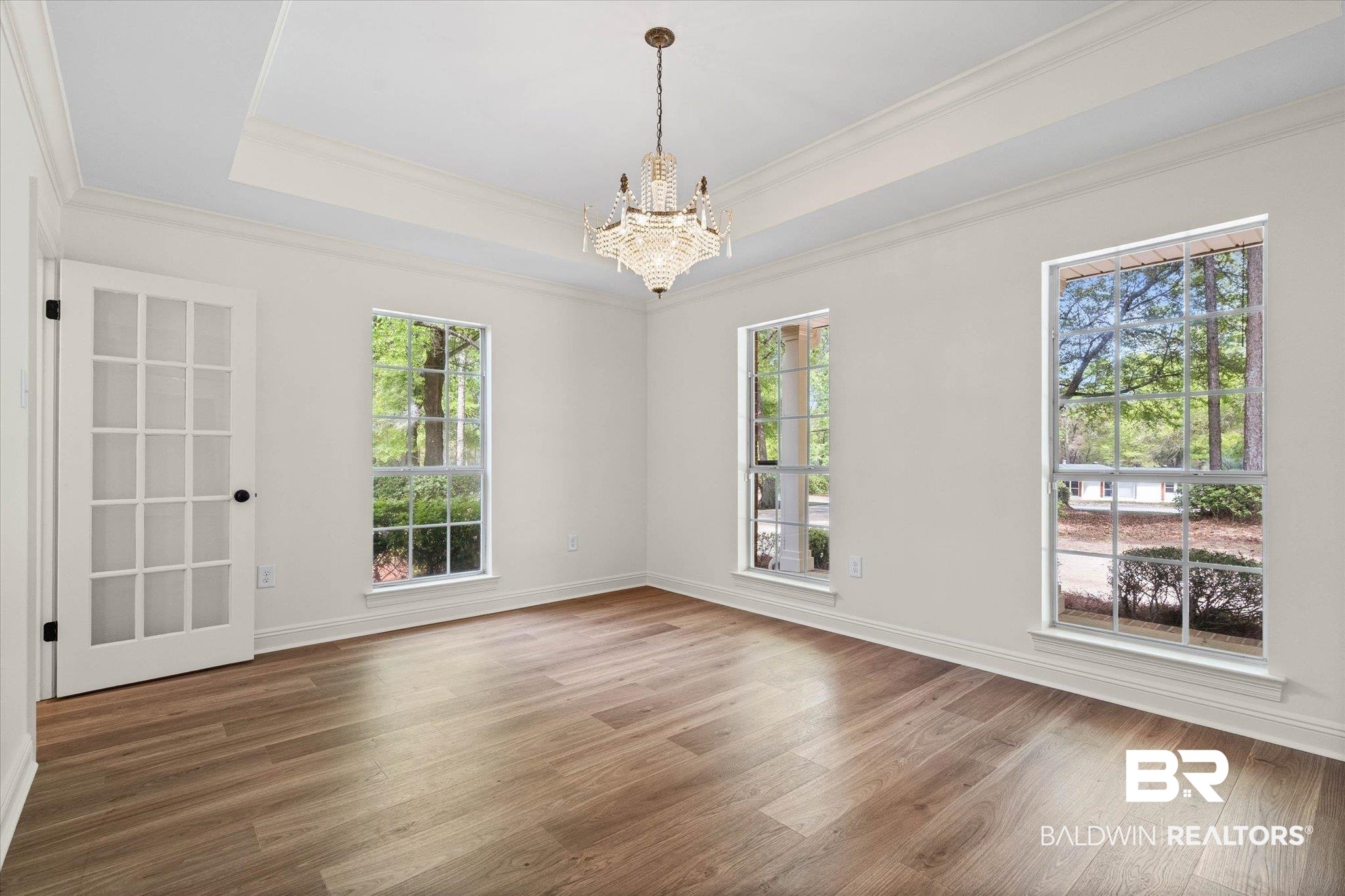 3451 Lacoste Road Mobile, AL 36618 - Photo 5 of 36 Unfurnished dining area with a chandelier, dark wood-style floors, a raised ceiling, and crown molding