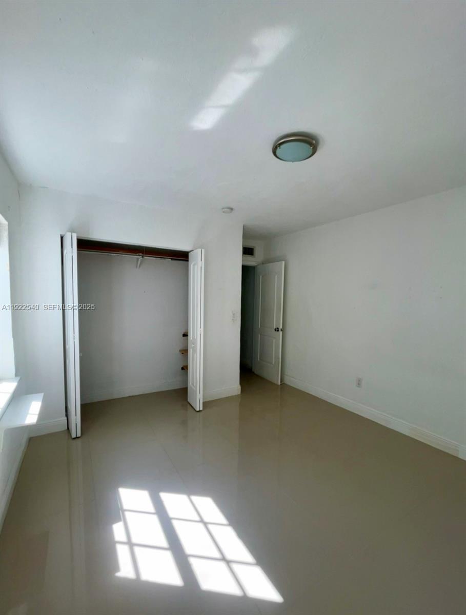 531 Northeast 68th Street, Unit 1 Miami, FL 33138 - Photo 7 of 11 an empty room with windows and closet