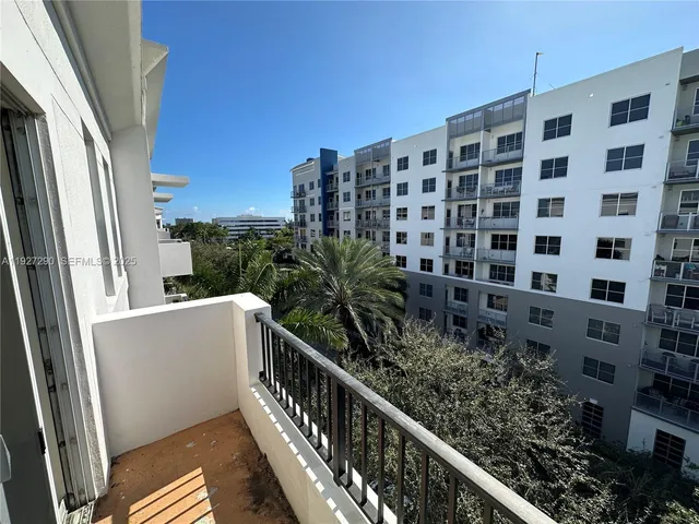 a view of a balcony with wooden floor and fence