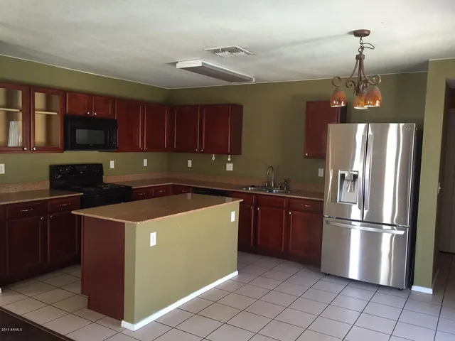 a kitchen with stainless steel appliances granite countertop a refrigerator a sink and a stove