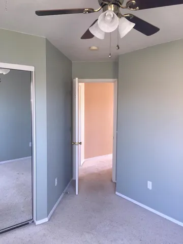 an empty room with a fan and a fan