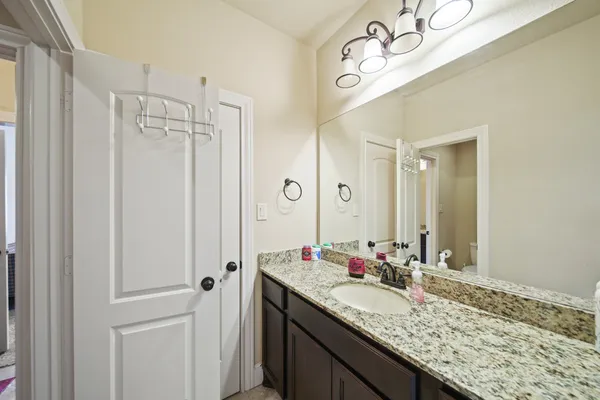 a bathroom with a granite countertop sink and a mirror