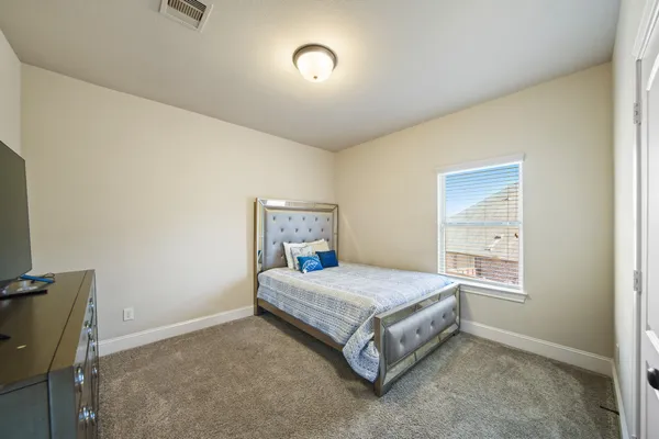 a bedroom with a bed and a window