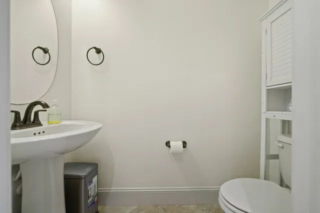 a bathroom with a sink a toilet and mirror