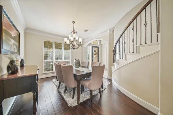 a view of a dining room with furniture a chandelier and wooden floor