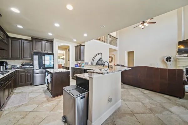 a large kitchen with kitchen island a sink a counter top stainless steel appliances and cabinets