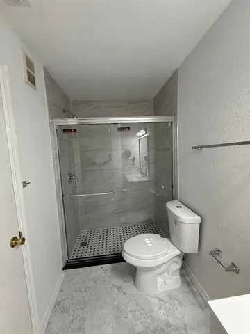 a bathroom with a toilet and a shower