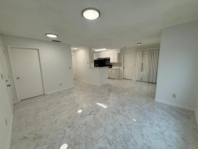 an empty room with a flat screen tv and windows