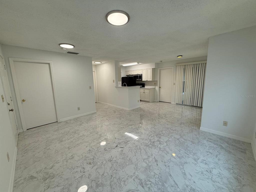 1089 South Hiawassee Road, Unit 314 Orlando, FL 32835 - Photo 2 of 24 an empty room with a flat screen tv and windows