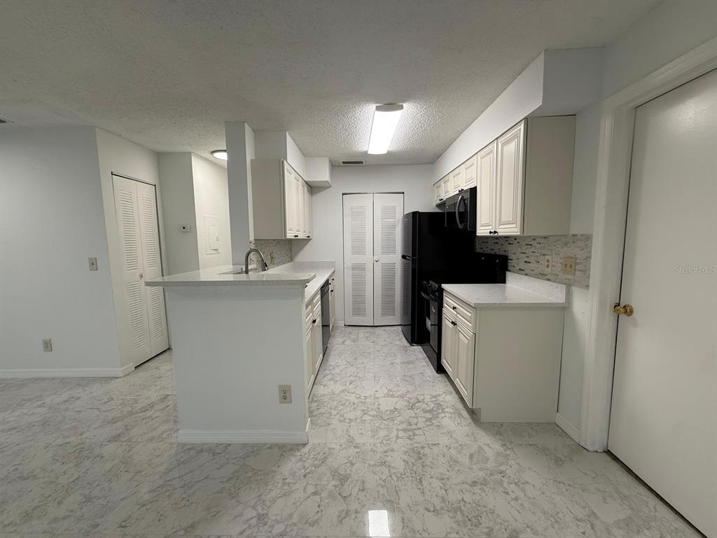 1089 South Hiawassee Road, Unit 314 Orlando, FL 32835 - Photo 8 of 24 a kitchen with refrigerator and cabinets