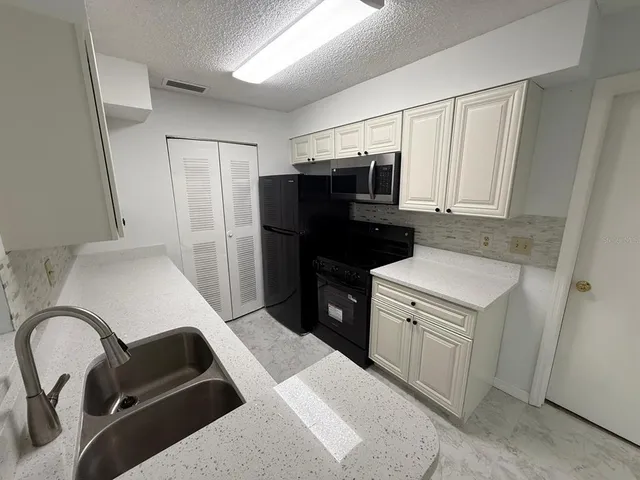 a kitchen with a refrigerator and a sink
