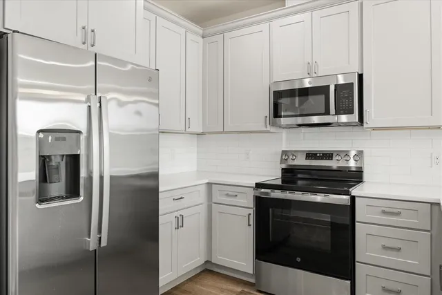 a kitchen with stainless steel appliances white cabinets and a stove