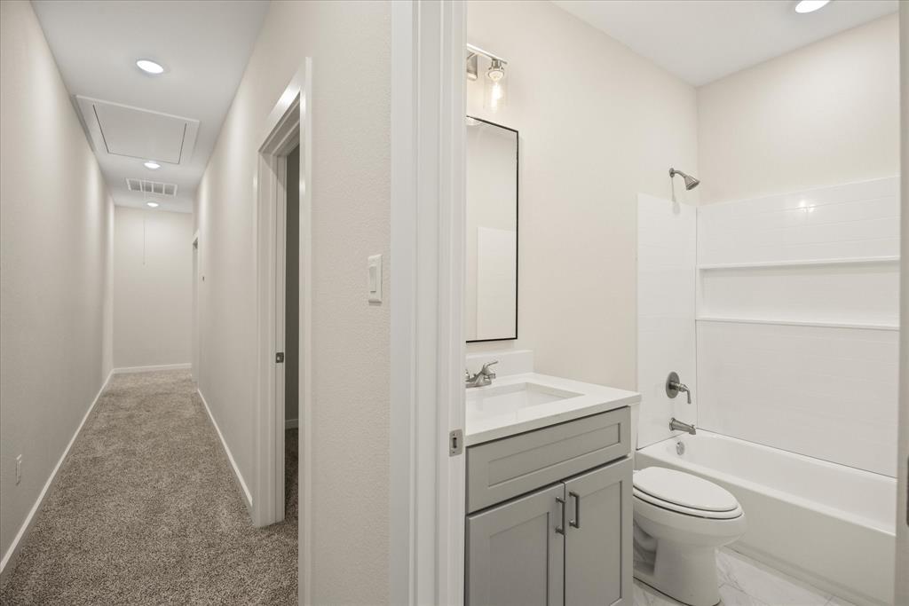 529 Galt Drive Stephenville, TX 76401 - Photo 24 of 27 a bathroom with a toilet a sink a mirror a shower and vanity