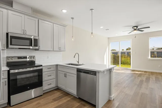 a kitchen with stainless steel appliances granite countertop a stove a sink and a microwave