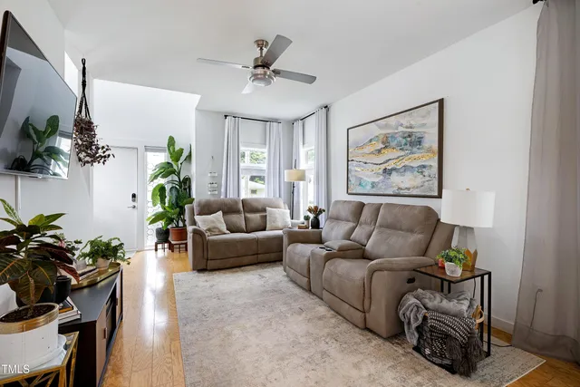 a living room with furniture wooden floor and a flat screen tv