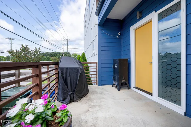 a view of a house with a yard and a large tree