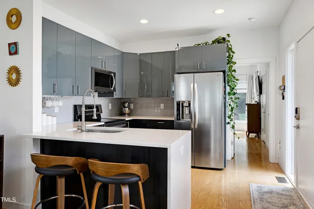 a kitchen with a refrigerator a microwave a sink and cabinets