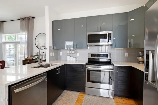 a kitchen with a sink and steel appliances