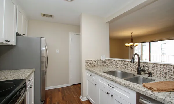 a kitchen with granite countertop a sink and a refrigerator