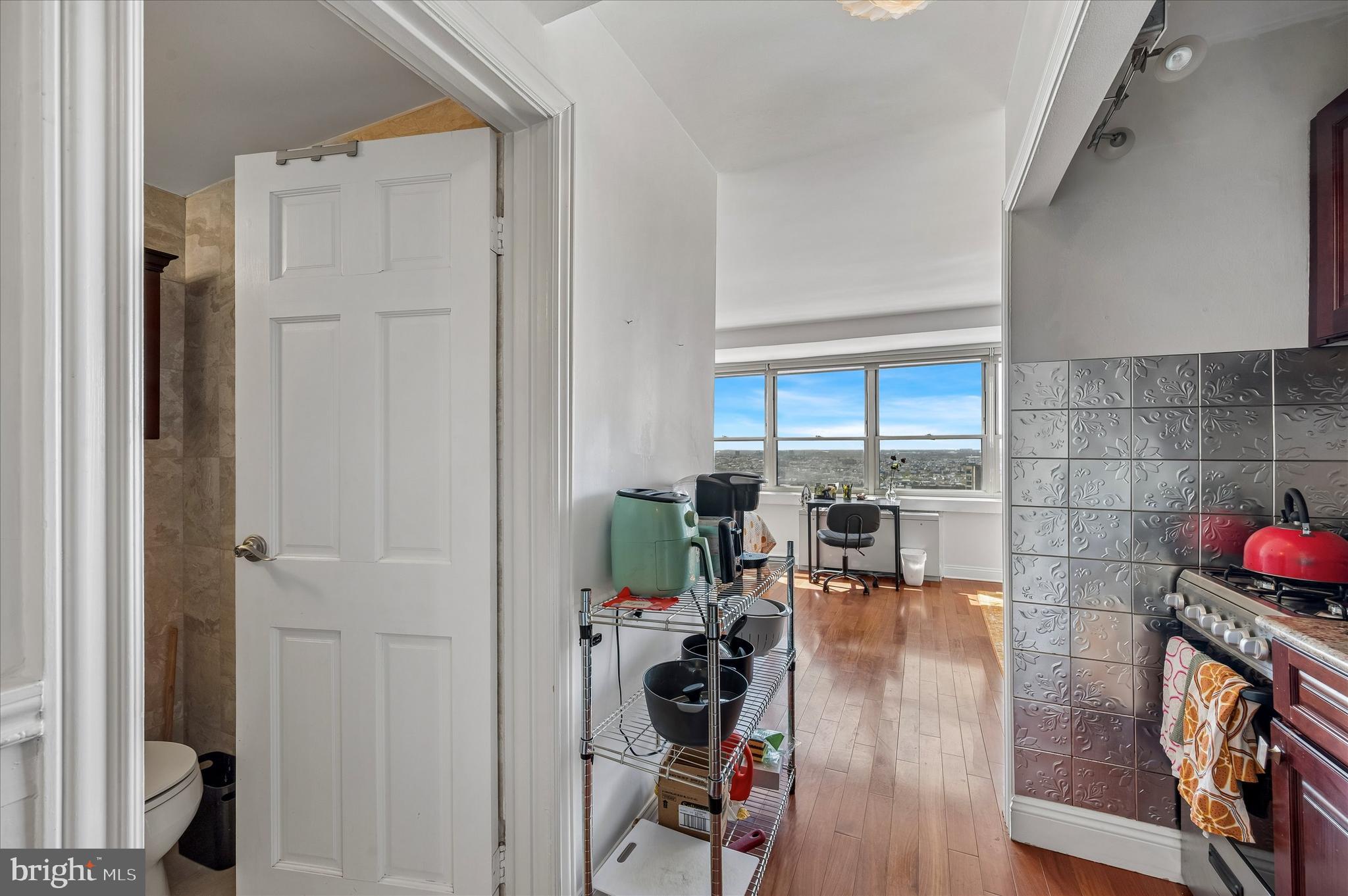 1810 Rittenhouse Square, Unit 2007 Philadelphia, PA 19103 - Photo 11 of 25 a hallway with wooden floor a dining table and chairs