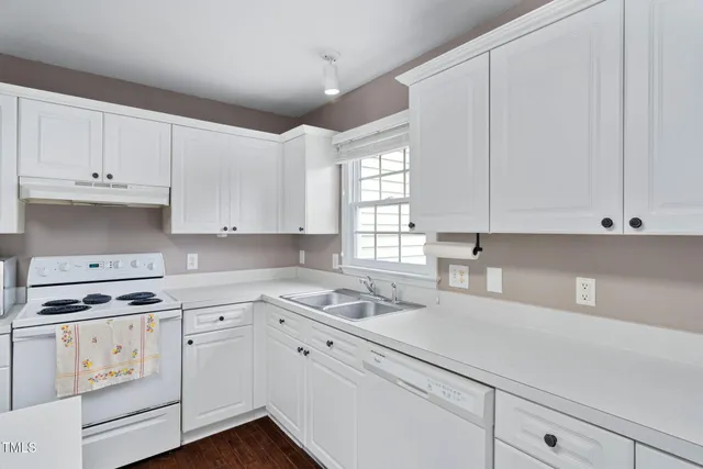 a kitchen with cabinets appliances a sink and a window
