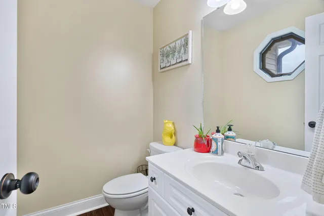 a bathroom with a sink vanity mirror and toilet
