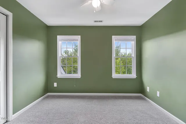 an empty room with a window and a fan