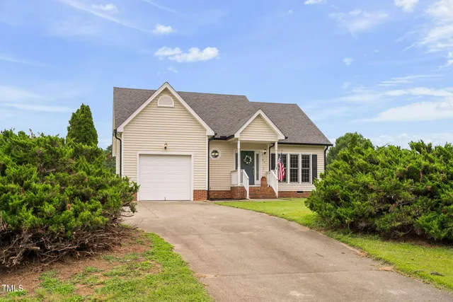 a front view of a house with a yard and potted plants